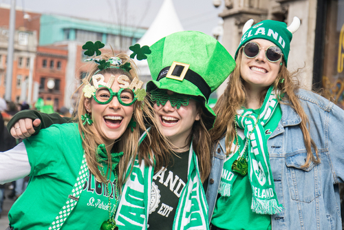 Three women celebrating St. Patrick's Day at a festival.